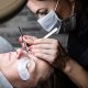 Een persoon die een wimperverlengingsbehandeling krijgt waarbij pads onder de ogen worden aangebracht.